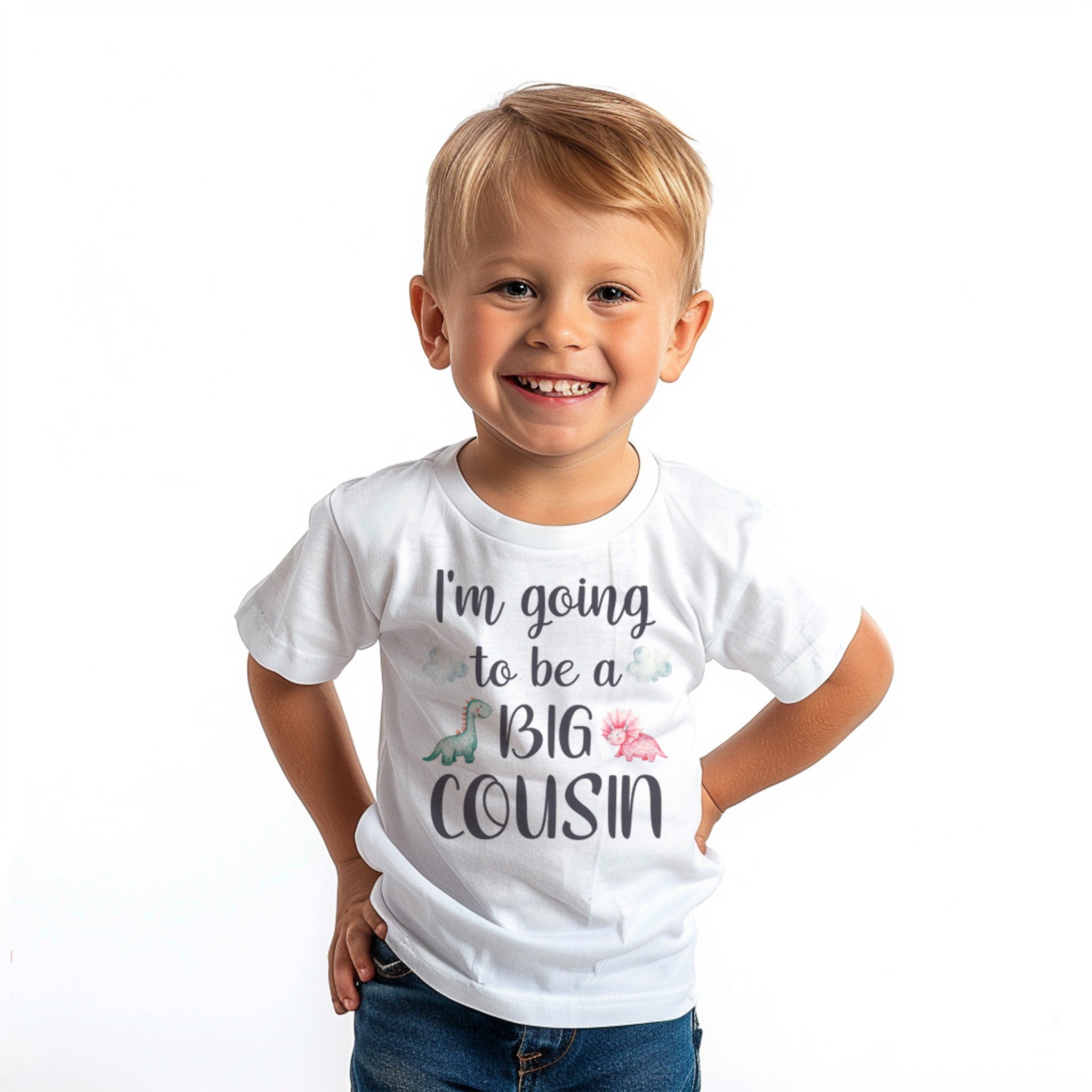 a white T-shirt with the phrase "I'm going to be a BIG COUSIN" printed on the front. The shirt features playful decorations such as a small green dinosaur and pink flowers near the text.