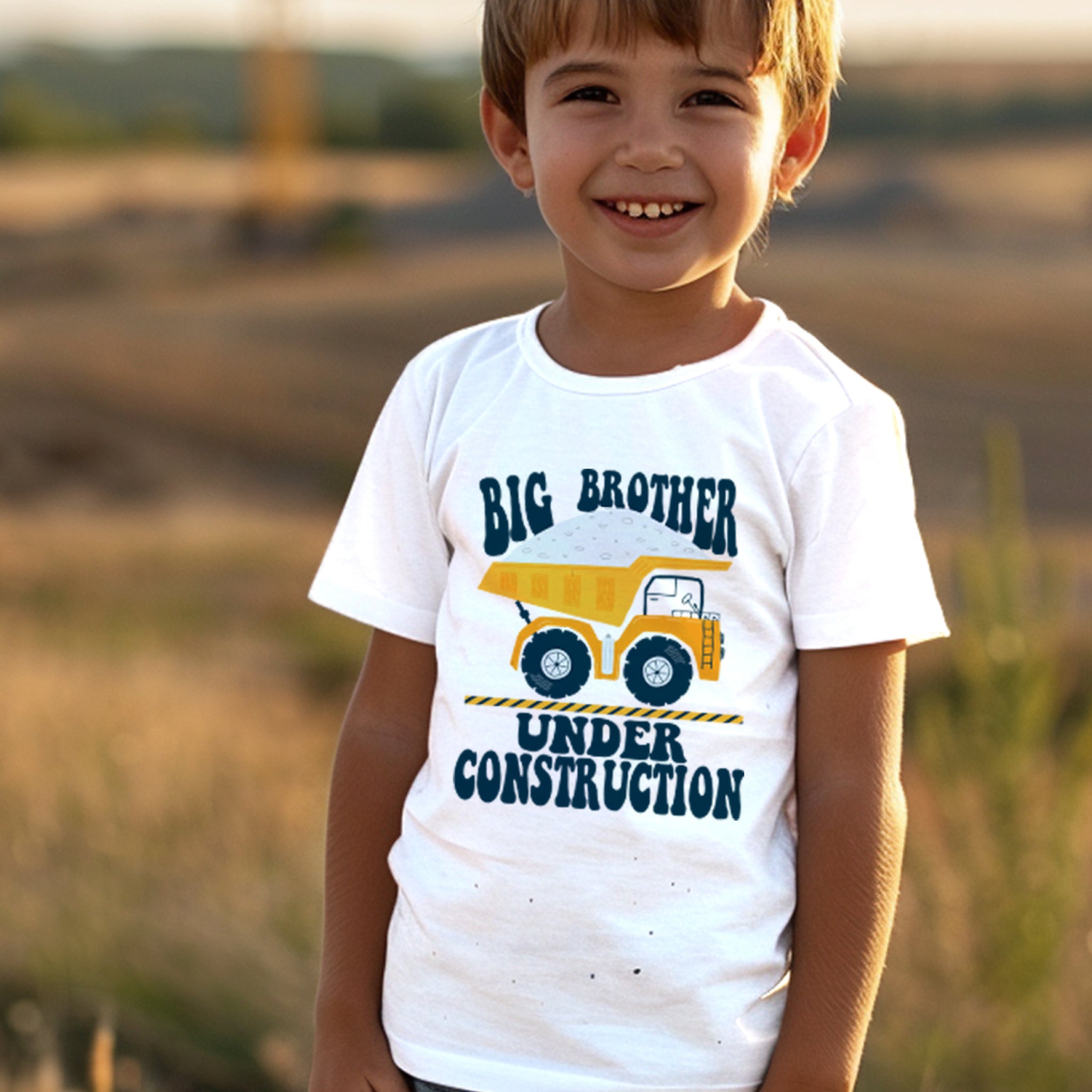 Trendy Tykes The shirt has a playful design with the words "BIG BROTHER" in bold letters, and an illustration of a yellow dump truck beneath. Under the truck, it reads "UNDER CONSTRUCTION," adding a fun, thematic element that ties into the big brother message, suggesting a new sibling is on the way.