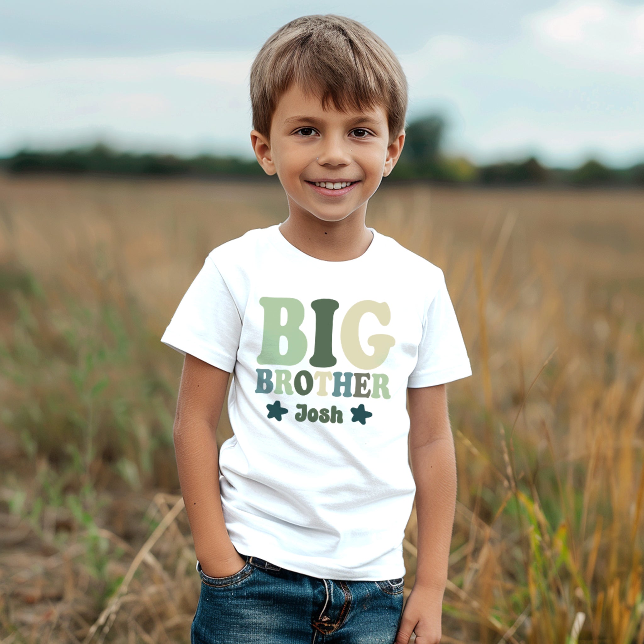 personalized white t-shirt by Trendy Tykes with the words "BIG BROTHER" above his name personalised name, both printed in varying shades of green. The design includes decorative stars, emphasizing the proud title of being a big brother.