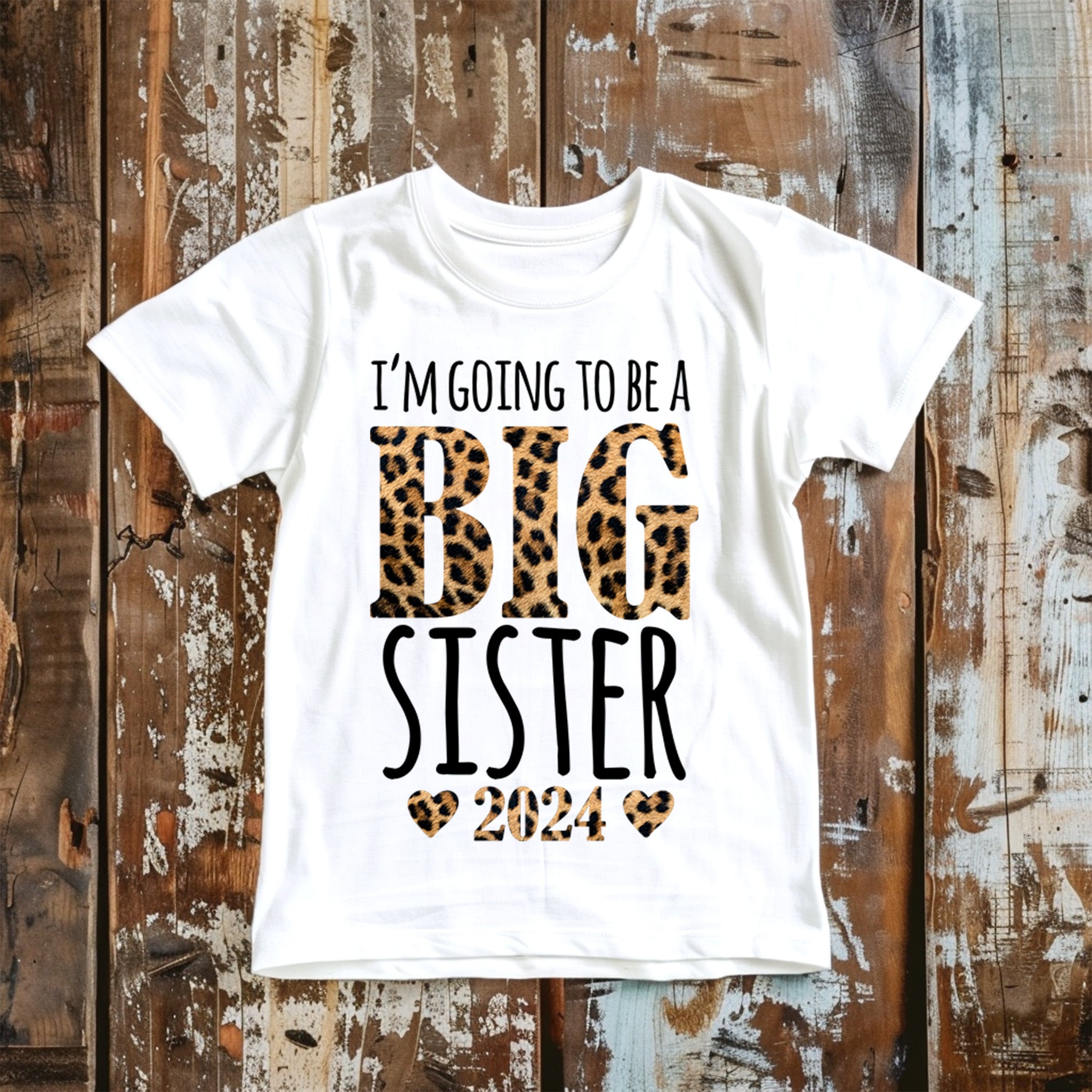 Trendy Tykes  t-shirt design charmingly announces a new role as a "Big Sister" with a playful and stylish font paired with leopard print details, making it a delightful choice for a little girl expecting a new sibling in 2024.
