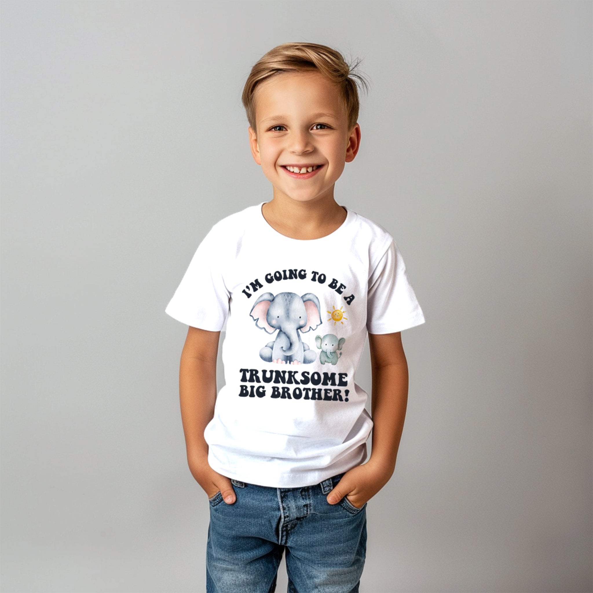 t-shirt carries an equally endearing message for a little boy. It says "I'M GOING TO BE A TRUNKSOME BIG BROTHER," featuring an adorable illustration of two elephants, which likely symbolizes the soon-to-be big brother and the new sibling. The pun "trunksome" is a cute play on words, relating to the elephants' trunks and the momentous task of becoming a big brother.