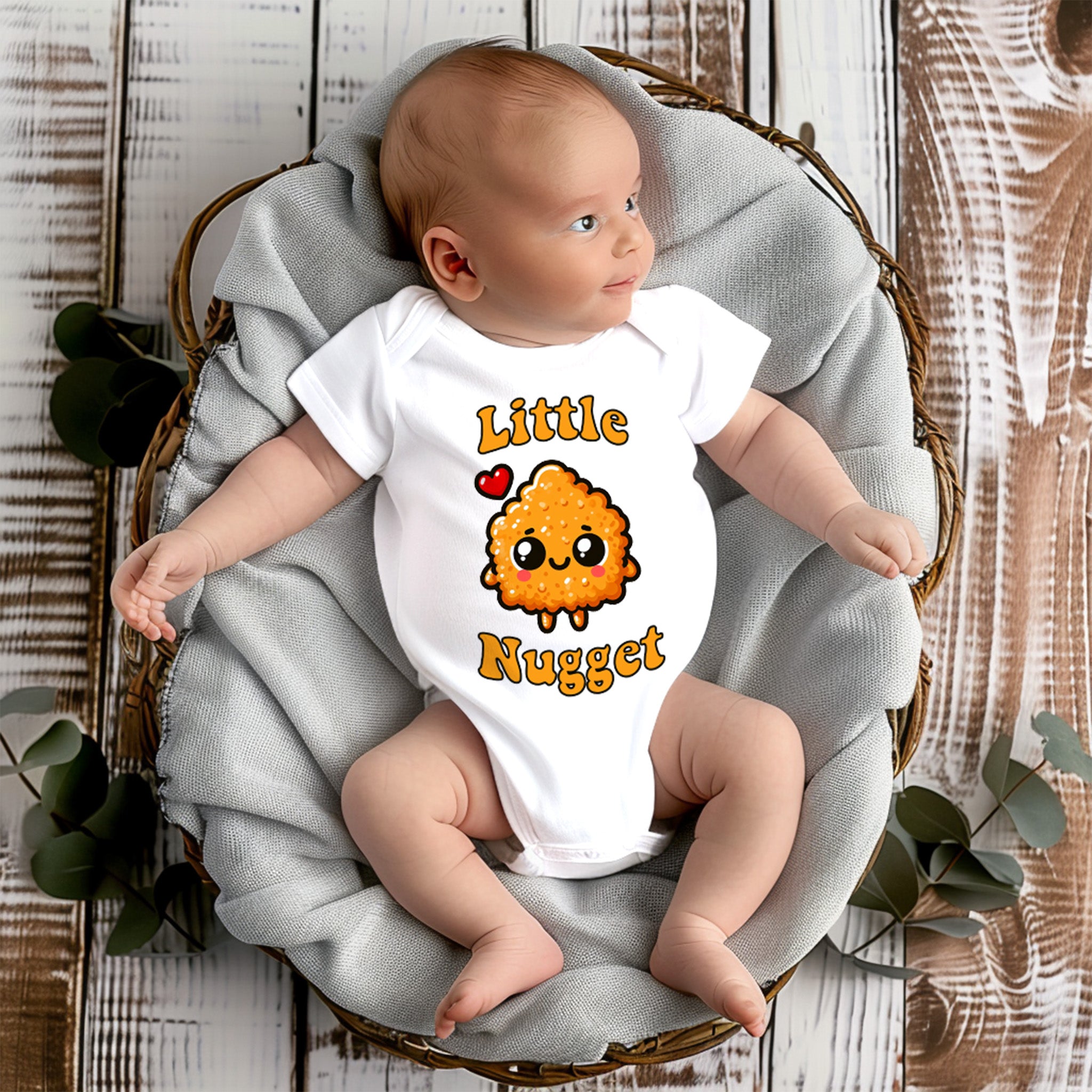 Trendy Tykes a white onesie with a graphic of a cute, smiling chicken nugget and the words "Little Nugget" printed on the front. A small red heart accents the phrase, adding to the cuteness of the design. 